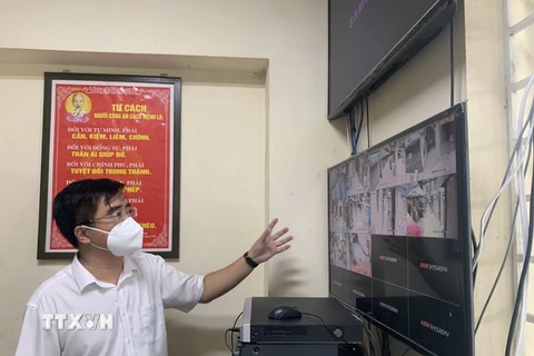 Chủ tịch UBND quận Thanh Xuân Võ Đăng Dũng theo dõi, điều hành việc di dời công dân qua hệ thống camera. (Ảnh: Văn Cảnh/TTXVN)
