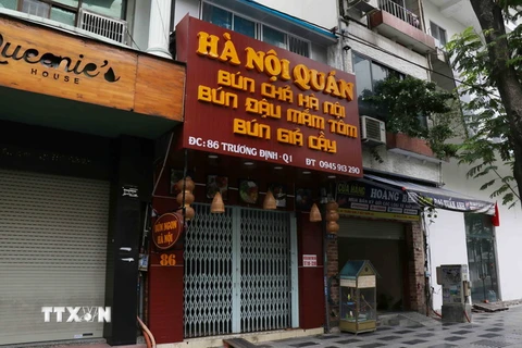 Các cửa hàng, quán ăn trên đường Trương Định, quận 1 nghiêm túc đóng cửa. (Ảnh: Xuân Khu/TTXVN)