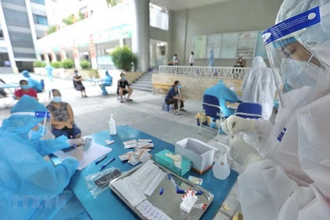 Nhân viên y tế lấy mẫu cho người dân phường Yên Hòa (quận Cầu Giấy). (Ảnh: Minh Quyết/TTXVN)