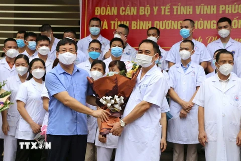 Chủ tịch UBND tỉnh Vĩnh Phúc Lê Duy Thành (trái, trước) thăm hỏi động viên trưởng đoàn công tác tại lễ xuất quân. (Ảnh: Hoàng Hùng/TTXVN)