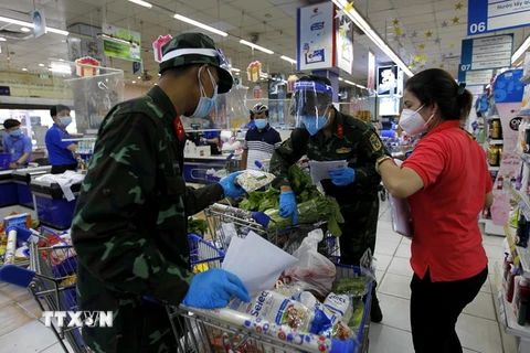 Nhiều chiến sỹ nhờ trợ giúp thông tin, hàng hóa từ các nhân viên siêu thị để "đi chợ giúp dân" đúng và đầy đủ theo nhu cầu." (Ảnh: Thanh Vũ/TTXVN)