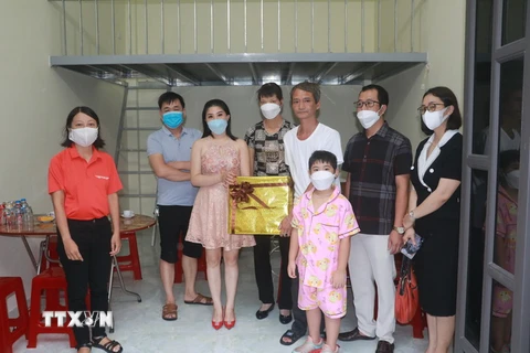 Đại diện các nhà hảo tâm trao quà và bàn giao nhà mới cho gia đình anh Lương Thanh Hà. (Ảnh: Nguyễn Lành/TTXVN)