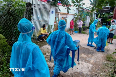 Đội tình nguyện đi lấy mẫu xét nghiệm cho người dân phường An Bình, quận Binh Kiều ngày 17/9. (Ảnh: Thanh Liêm/TTXVN)