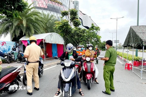 Lực lượng Công an tại chốt kiểm trên đường Phạm Văn Đồng, phường Hiệp Bình Chánh, Thủ Đức, kiểm tra giấy tờ của người lưu thông. (Ảnh: Thành Chung/TTXVN)