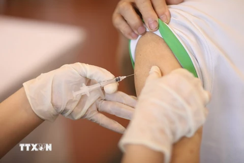 Nhân viên y tế tiêm vaccine phòng COVID-19 cho người dân quận Hoàn Kiếm. (Ảnh: Minh Quyết/TTXVN)