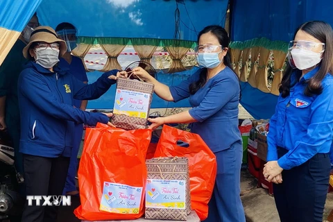 Tỉnh Đoàn Quảng Trị trao tặng quà cho các hộ dân có hoàn cảnh khó khăn tại các khu vực phong tỏa trên địa bàn thành phố Đông Hà. (Ảnh: Hồ Cầu/TTXVN)