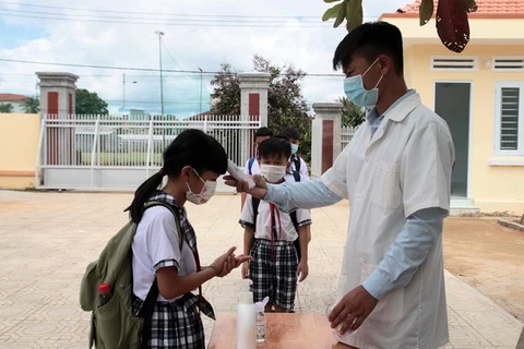 Học sinh được đo thân nhiệt, rửa tay sát khuẩn trước khi vào lớp. (Nguồn: baolamdong)