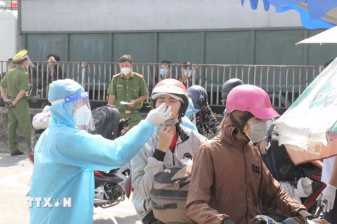 Tổ chức test nhanh COVID-19 cho người dân trước khi qua chốt kiểm soát để về quê tại khu vực Thị trấn Tân Túc, huyện Bình Chánh, TP Hồ Chí Minh. (Ảnh: TTXVN phát)