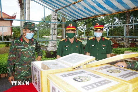 Bộ Chỉ huy quân sự tỉnh Bạc Liêu tổ chức tiếp nhận và kiểm tra tro cốt nhân dân tử vong do COVID-19 trước khi bàn giao cho gia đình. (Ảnh: Nhật Bình/TTXVN)