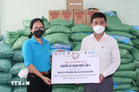 Bà Bùi Thị Cẩm Huyền, Phó Chủ nhiệm Câu lạc bộ Thiện Minh Sài Gòn trao 5 tấn nông sản và 150 túi an sinh tặng các gia đình có hoàn cảnh khó khăn do đại dịch. (Ảnh: TTXVN phát)