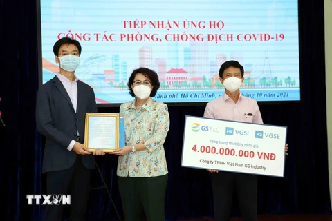Bà Tô Thị Bích Châu, Chủ tịch Ủy ban MTTQ Việt Nam Thành phố Hồ Chí Minh (giữa) trao thư cảm ơn các doanh nghiệp Hàn Quốc đã ủng hộ công tác phòng, chống dịch COVID-19. (Ảnh: Xuân Khu/TTXVN)