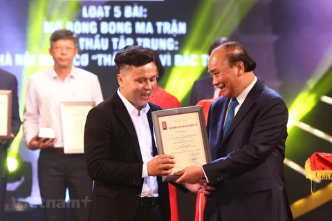Thủ tướng Nguyễn Xuân Phúc trao giải A, Giải Báo chí Quốc gia lần thứ XIV-năm 2020 cho đại diện nhóm tác giả Báo Điện tử VietnamPlus. (Ảnh: Nguyên An/Vietnam+)