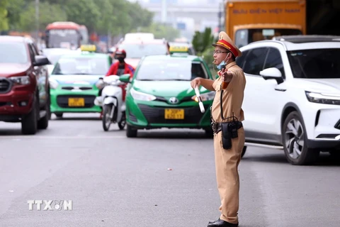 Lực lượng CSGT số 6 Công an thành phố Hà Nội chủ động phân luồng và điều tiết giao thông tại khu vực Bến xe Mỹ Đình. (Ảnh: Phạm Kiên/TTXVN)