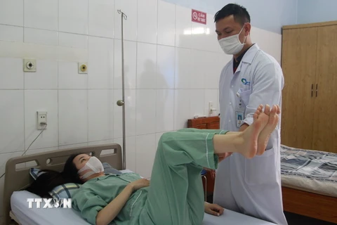 Bác sỹ Bệnh viện Bãi Cháy kiểm tra cử động của bệnh nhân Nguyễn Minh Nguyệt sau khi phẫu nắn vẹo cột sống thành công. (Ảnh: TTXVN phát)
