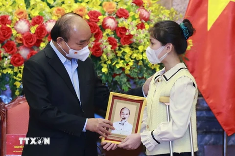 Chủ tịch nước Nguyễn Xuân Phúc tặng chân dung Chủ tịch Hồ Chí Minh cho học sinh xuất sắc trong cuộc thi “Vì một Việt Nam tất thắng.” (Ảnh: Thống Nhất/TTXVN)