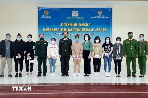 Bàn giao 14 nạn nhân bị mua bán sang Myanmar về Việt Nam. (Ảnh: TTXVN phát)