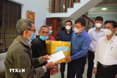 Thứ trưởng Bộ Nông nghiệp và Phát triển Nông thôn Nguyễn Hoàng Hiệp trao tiền hỗ trợ của Thủ tướng Phạm Minh Chính cho gia đình có người mất do mưa lụt gây ra tại Bình Định. (Ảnh: Tường Quân/TTXVN)