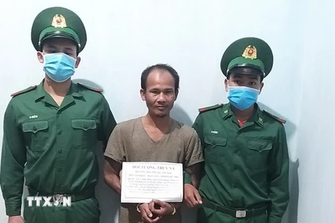 Đối tượng Trương Quang Đại (giữa) bị lực lượng chức năng bắt giữ. (Ảnh: TTXVN phát)
