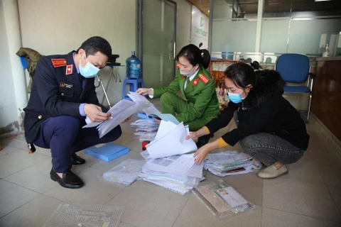 Lực lượng chức năng khám xét cơ sở tín dụng của Tân Tín Đạt. (Nguồn: tienphong.vn)