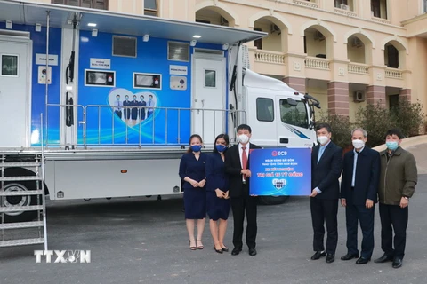 Đại diện Ngân hàng Thương mại cổ phần Sài Gòn trao xe xét nghiệm COVID-19 lưu động cho lãnh đạo tỉnh Nam Định. (Ảnh: Văn Đạt/TTXVN)