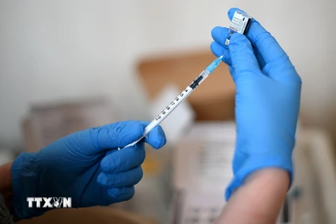 Nhân viên y tế chuẩn bị tiêm vaccine phòng COVID-19 cho người dân. (Ảnh: AFP/TTXVN)