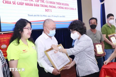 Bà Tô Thị Bích Châu, Chủ tịch Ủy ban MTTQ Việt Nam Thành phố Hồ Chí Minh trao Giấy Biểu dương và biểu trưng tri ân các tổ chức thiện nguyện. (Ảnh: Xuân Khu/TTXVN)