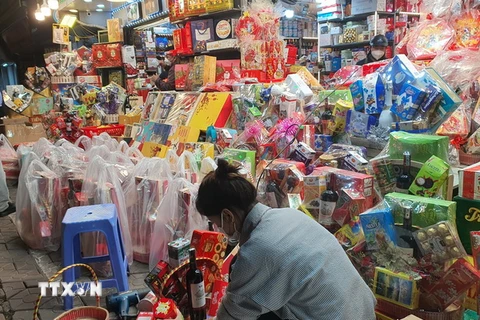Đóng giỏ quà Tết tại cửa hàng tạp hóa Minh Tâm, 108 A12 Nghĩa Tân, quận Cầu Giấy, Hà Nội. (Ảnh: Phương Anh/TTXVN)