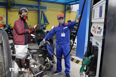 Mua bán xăng, dầu tại một cửa hàng kinh doanh xăng, dầu của Tập đoàn xăng dầu Việt Nam ở Hà Nội. (Ảnh: Trần Việt/TTXVN)