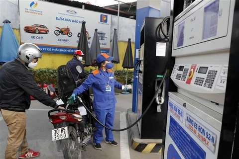 Mua bán xăng, dầu tại một cửa hàng kinh doanh xăng, dầu của Tập đoàn xăng dầu Việt Nam ở Hà Nội. (Ảnh: TTXVN)