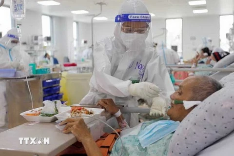 Điều dưỡng viên tận tình chăm sóc bệnh nhân COVID-19 nặng được điều trị tích cực tại Bệnh viện hồi sức COVID-19 Thành phố Hồ Chí Minh. (Ảnh: Thanh Vũ/TTXVN)
