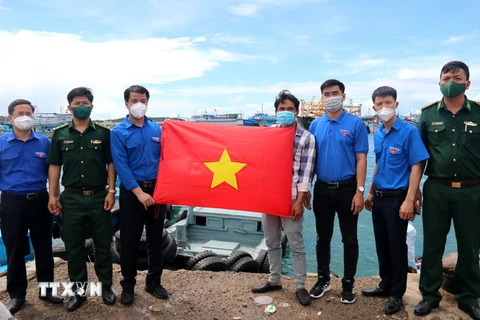 Trung ương Đoàn Thanh niên Cộng sản Hồ Chí Minh tặng cờ Tổ quốc cho ngư dân huyện đảo Phú Quý, tỉnh Bình Thuận. (Ảnh: Nguyễn Thanh/TTXVN)