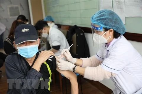 Nhân viên y tế tiêm vaccine phòng COVID-19 cho người dân. (Ảnh: Minh Quyết/TTXVN)