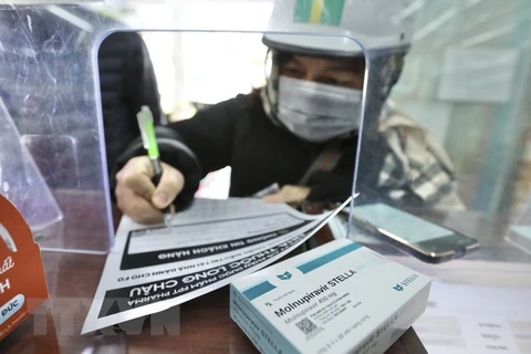 Người dân mua thuốc Molnupiravir điều trị COVID-19 tại cửa hàng thuốc Long Châu, Hà Nội. (Ảnh: Minh Quyết/TTXVN)