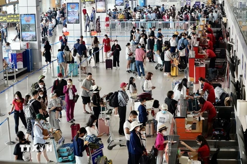 Hành khách làm thủ tục lên máy bay tại khu vực của hãng hàng không Vietjet ở Cảng Hàng không quốc tế Nội Bài. (Ảnh: Huy Hùng/TTXVN)