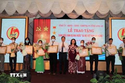 Phó Chủ tịch UBND tỉnh Long An Phạm Tấn Hòa trao tặng danh hiệu cho thân nhân Mẹ Việt Nam anh hùng. (Ảnh: Đức Hạnh/TTXVN)