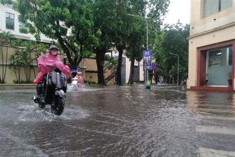 Các phương tiện di chuyển khó khăn trên phố Lê Thánh Tôn, Hà Nội sau cơn mưa. (Ảnh: Phạm Hậu/TTXVN)
