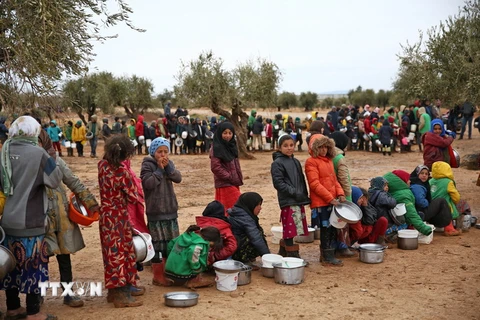 Người dân xếp hàng chờ được phát lương thực cứu trợ tại trại tị nạn ở Yazi Bagh, Aleppo, Syria. (Ảnh: AFP/TTXVN)