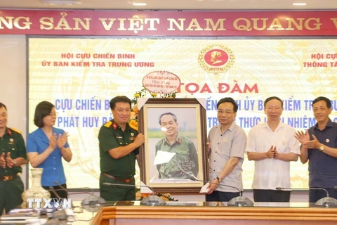 Hội Cựu chiến binh TTXVN tặng quà lưu niệm cho Hội Cựu chiến binh Ủy ban Kiểm tra Trung ương. (Ảnh: Tuấn Đức/TTXVN)