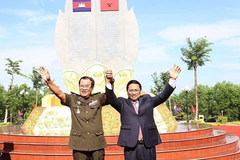 Thủ tướng Phạm Minh Chính và Thủ tướng Campuchia Hun Sen thể hiện tình đoàn kết tại Khu vực X16, điểm dừng chân trong hành trình cứu nước của Thủ tướng Hun Sen ở xã Lộc Tấn, huyện Lộc Ninh, tỉnh Bình Phước, sáng 20/6/2022. (Ảnh: Dương Giang/TTXVN)
