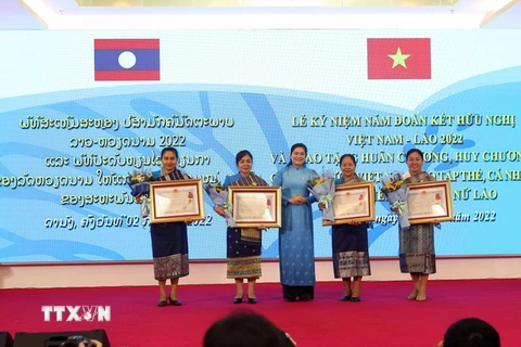 Bà Hà Thị Nga, Ủy viên Trung ương Đảng, Chủ tịch Hội Liên hiệp Phụ nữ Việt Nam trao tặng Huân chương, Huy chương cho các tập thể, cá nhân Hội Liên hiệp Phụ nữ Lào. (Ảnh: Trần Lê Lâm/TTXVN)