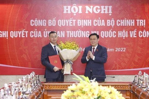 Chủ tịch Quốc hội Vương Đình Huệ trao Quyết định của Bộ Chính trị và tặng hoa ông Ngô Văn Tuấn. (Ảnh: Doãn Tấn/TTXVN)