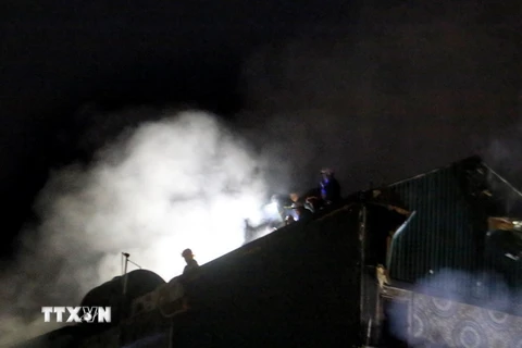 Lực lượng Phòng cháy, chữa cháy tiếp tục dùng vòi phun nước vào khu vực có khói bốc lên. (Ảnh: Phạm Kiên/TTXVN)