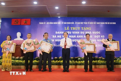 Bí thư Thành ủy Thành phố Hồ Chí Minh Nguyễn Văn Nên truy tặng danh hiệu Bà mẹ Việt Nam Anh hùng cho gia đình các mẹ. (Ảnh: Thanh Vũ/TTXVN)