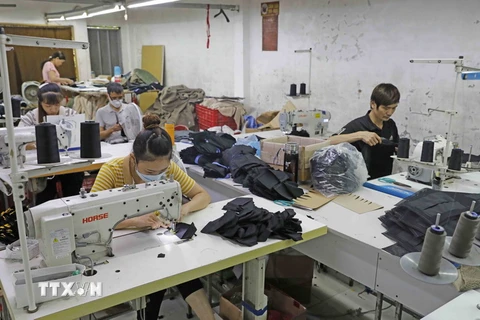 May hàng xuất khẩu tại Công ty TNHH May mặc Hồng Quang. (Ảnh: Trần Việt/TTXVN)