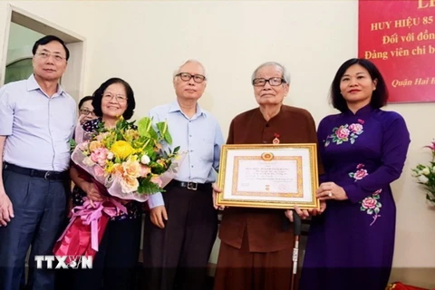 Phó Bí thư Thường trực Thành ủy Hà Nội Nguyễn Thị Tuyến trao tặng huy hiệu 85 năm tuổi Đảng cho lão thành cách mạng Mai Vy. (Ảnh: TTXVN phát)