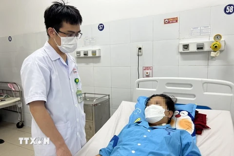 Bác sỹ Bệnh viện Đà Nẵng thăm hỏi sản phụ sau khi được cứu sống bằng kỹ thuật ECMO. (Ảnh: TTXVN phát)