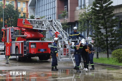 Phối hợp với lực lượng Đan Phượng, lực lượng PCCC Thành phố Hà Nội điều động xe giỏ thang đến hiện trường đưa người bị nạn từ các tầng cao ra khỏi hiện trường vụ cháy. (Ảnh: Hoàng Hiếu/TTXVN)