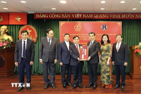 Đoàn đại biểu Viện Kiểm sát Nhân dân Tối cao Lào trao quà lưu niệm hữu nghị cho Viện Kiểm sát Nhân dân Thành phố Hồ Chí Minh tại buổi làm việc. (Ảnh: Hồng Giang/TTXVN)