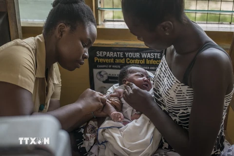 Nhân viên y tế tiêm vaccine ngừa sốt rét cho trẻ em tại Cape Coast, Ghana ngày 30/4/2019. (Ảnh: AFP/TTXVN)