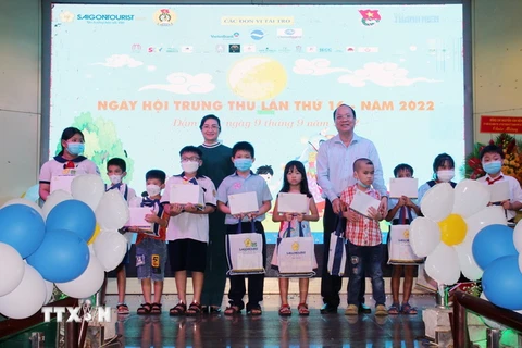 Đại diện Lãnh đạo UBND Thành phố Hồ Chí Minh, sở ngành, đoàn thể và Ban tổ chức trao quà cho các em thiếu nhi tham gia Ngày hội Trung thu lần thứ 16 năm 2022. (Ảnh:Trần Thị Mỹ Phương/TTXVN)